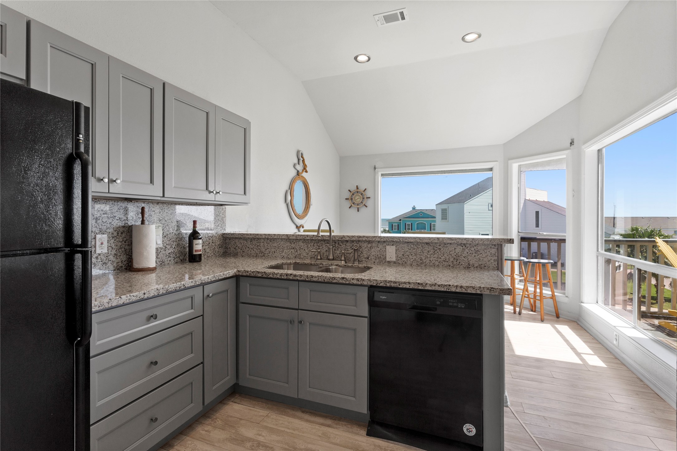 17627 Termini-San Luis Pass Road Galveston, TX 77554 - Photo 5 of 28 Kitchen with breakfast bar, granite countertops, and updated cabinetry opens to dining area.