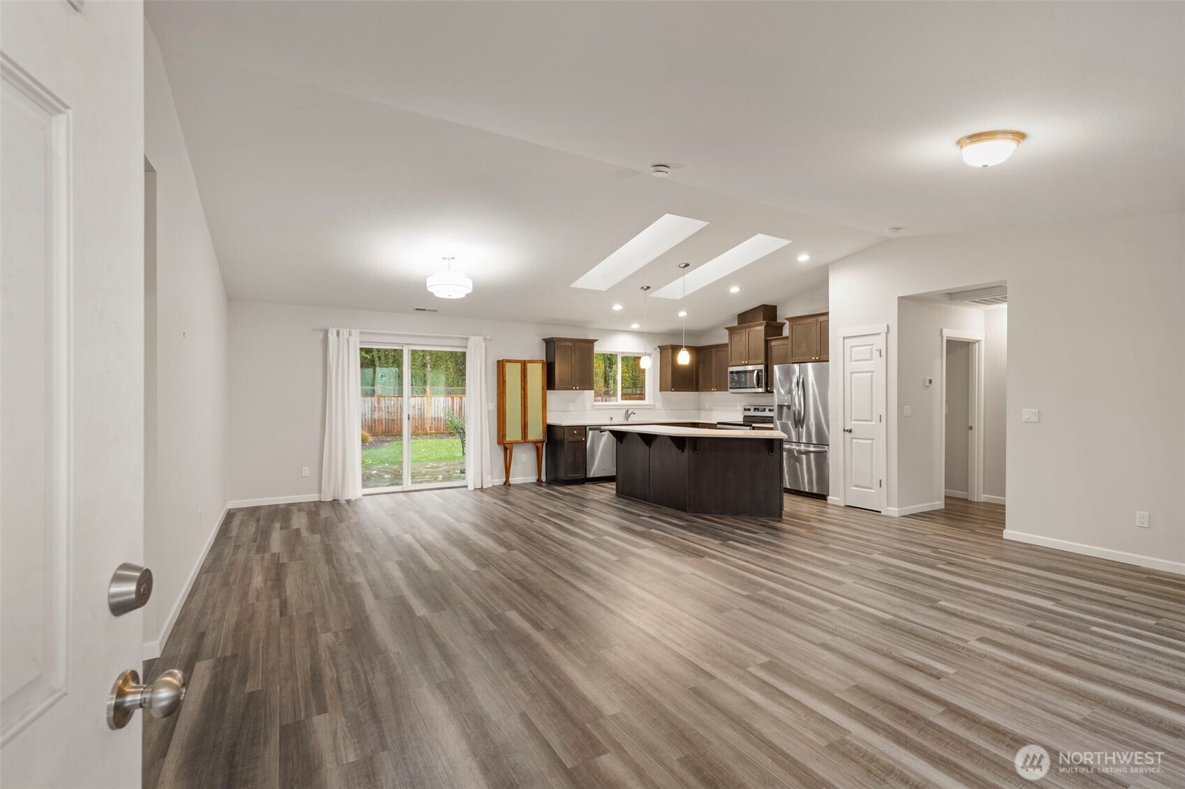 174 East Island View Avenue Port Townsend, WA 98368 - Photo 6 of 39 a large white kitchen with kitchen island a sink wooden floor and stainless steel appliances