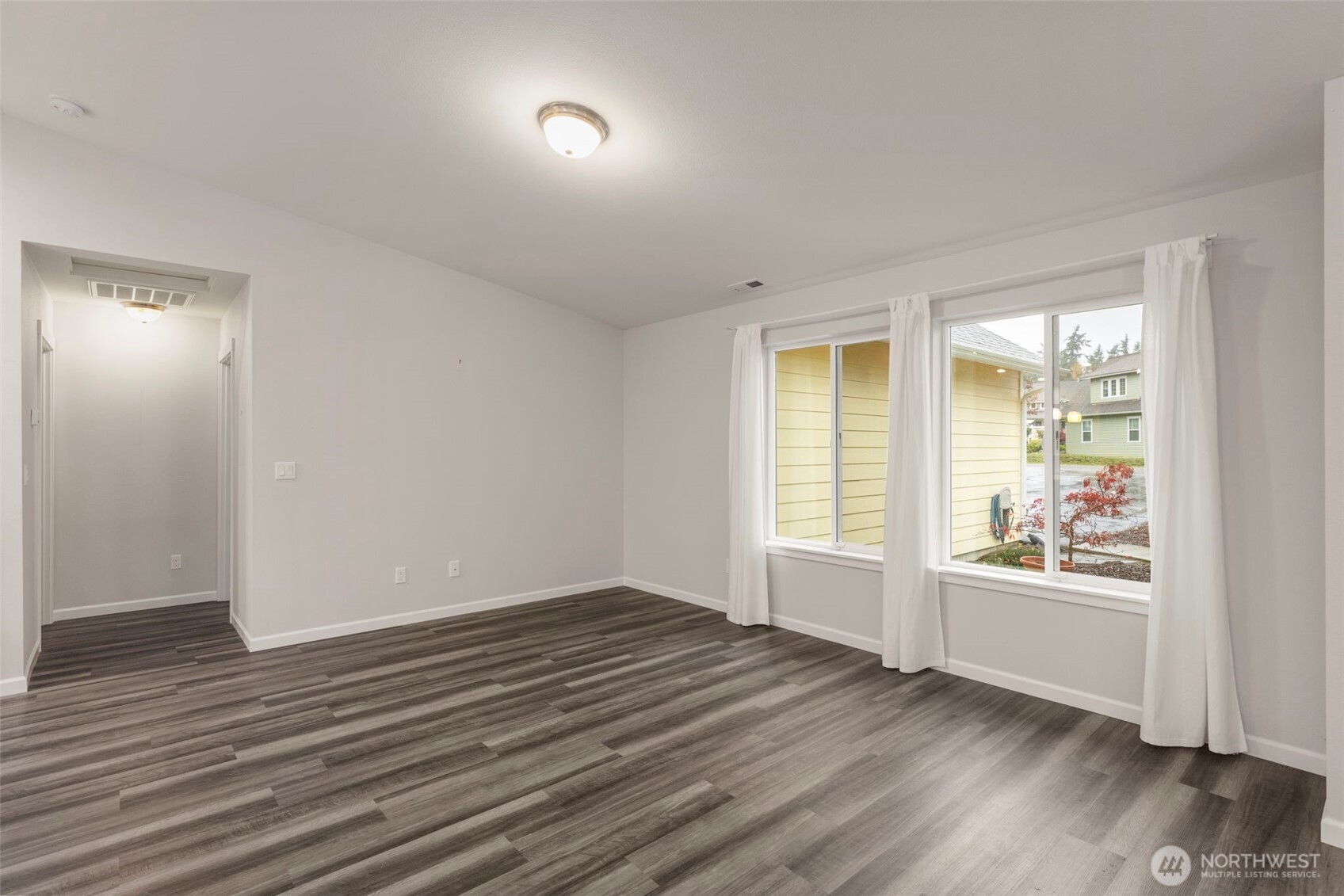 174 East Island View Avenue Port Townsend, WA 98368 - Photo 8 of 39 an empty room with wooden floor and windows