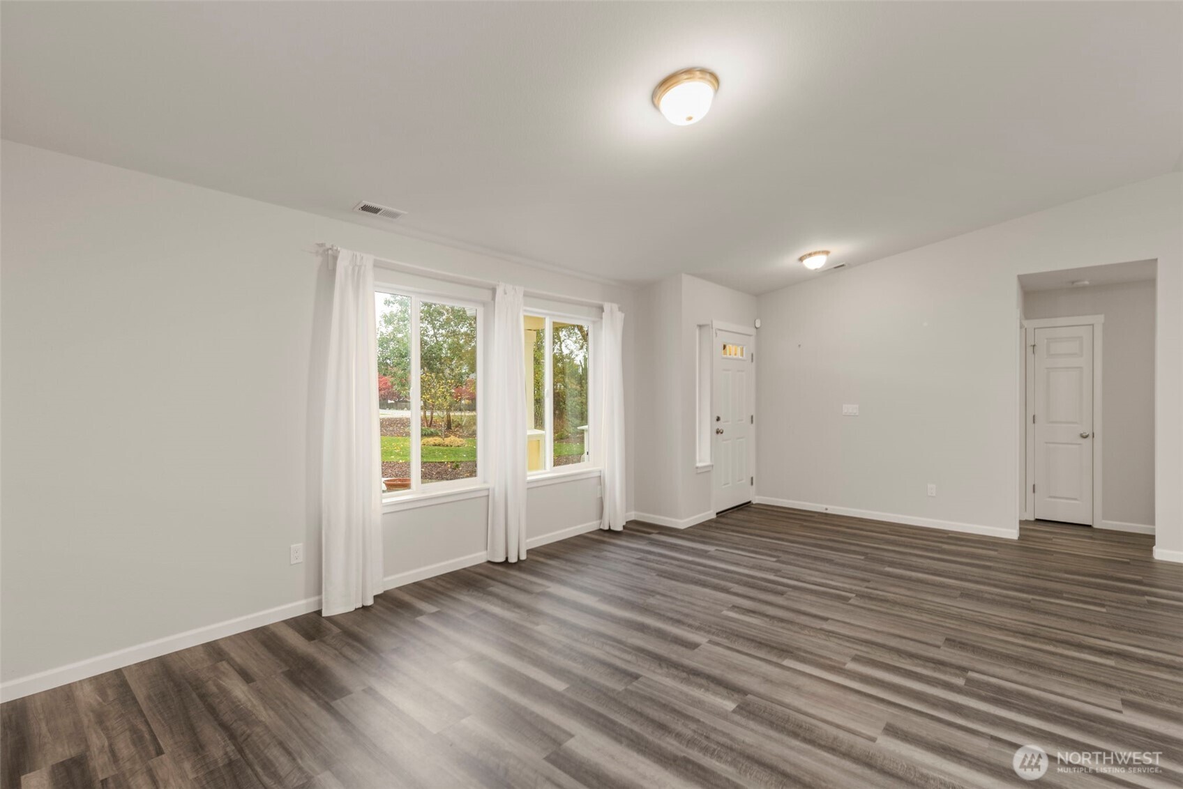 174 East Island View Avenue Port Townsend, WA 98368 - Photo 10 of 39 an empty room with wooden floor and windows