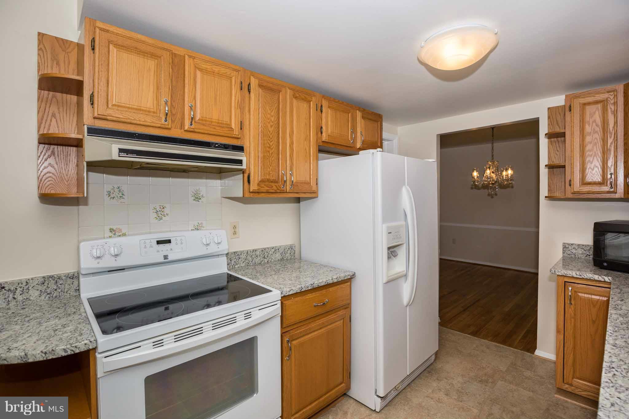 13405 Tamarack Road Silver Spring, MD 20904 - Photo 12 of 30 a kitchen with granite countertop a refrigerator stove and cabinets