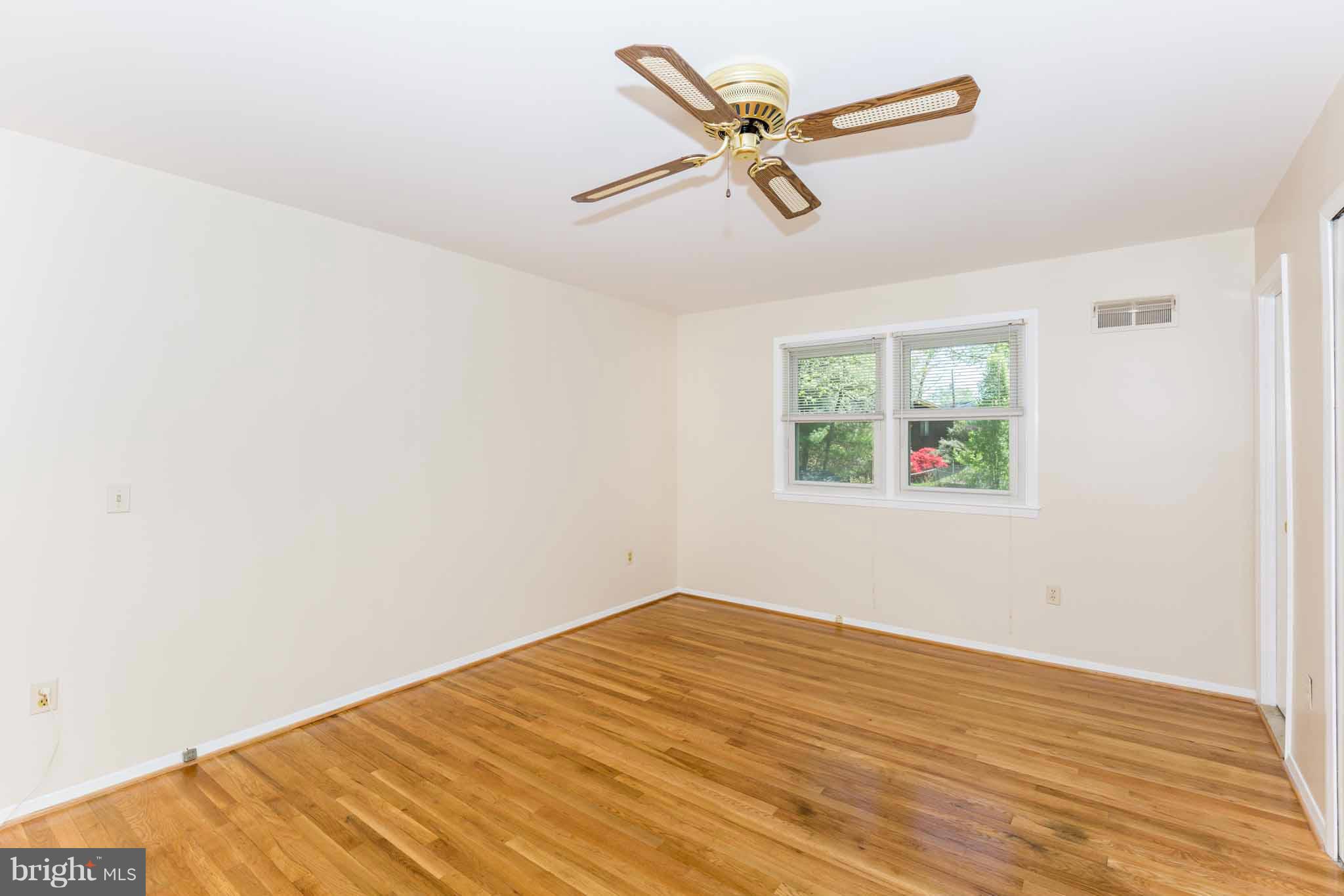 13405 Tamarack Road Silver Spring, MD 20904 - Photo 6 of 30 an empty room with wooden floor fan and windows