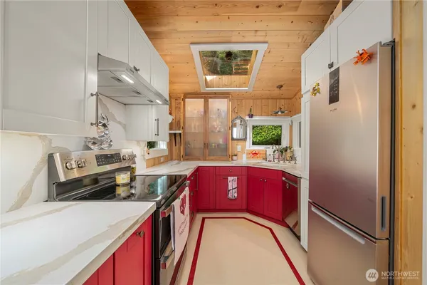 a kitchen with stainless steel appliances granite countertop a refrigerator a stove and a sink with wooden floor
