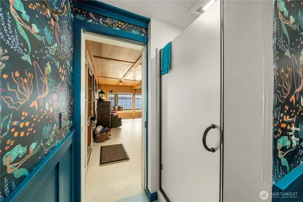 a view of a hallway with wooden floor and a dining room