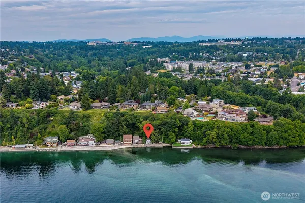 an aerial view of lake and residential houses with outdoor space and trees