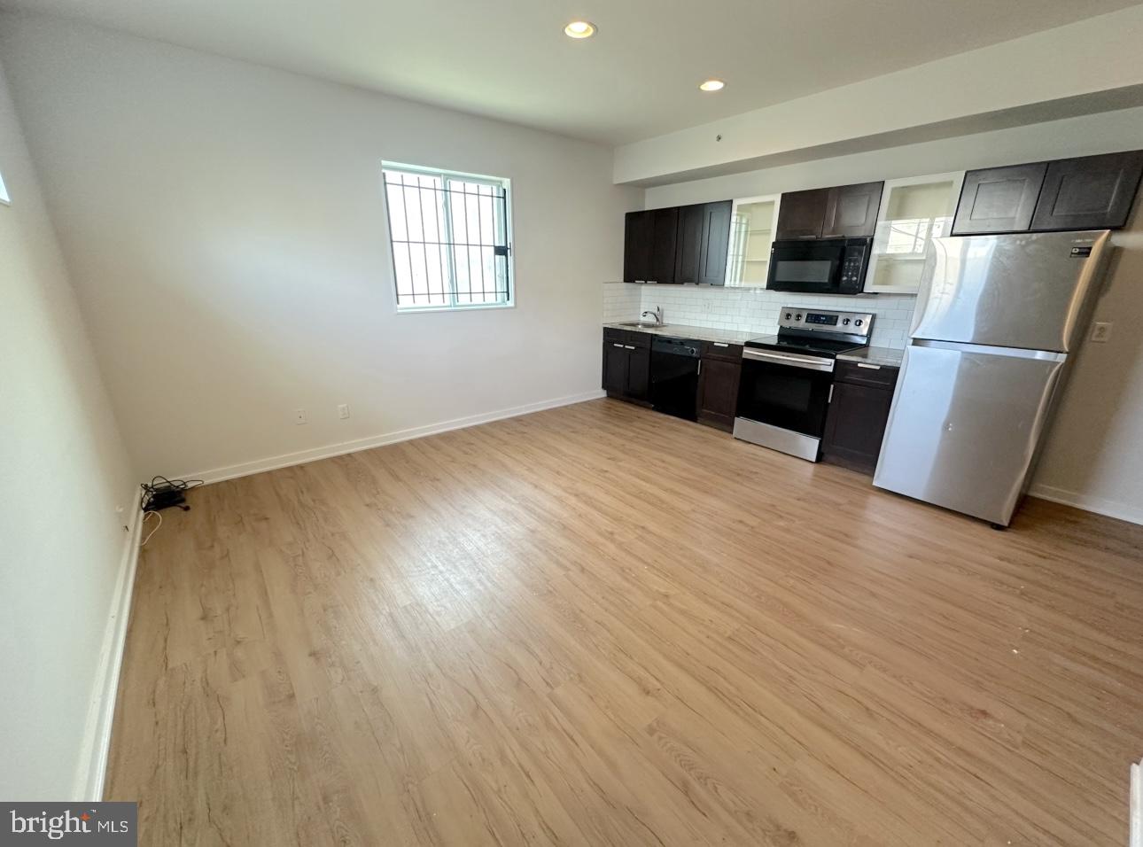 1324 North 17th Street, Unit 3 Philadelphia, PA 19121 - Photo 2 of 12 a kitchen with granite countertop stainless steel appliances a refrigerator microwave and sink