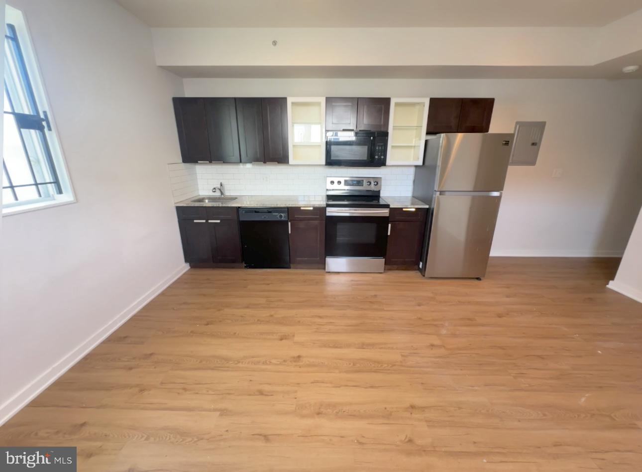 1324 North 17th Street, Unit 3 Philadelphia, PA 19121 - Photo 3 of 12 a kitchen with stainless steel appliances a refrigerator stove and microwave