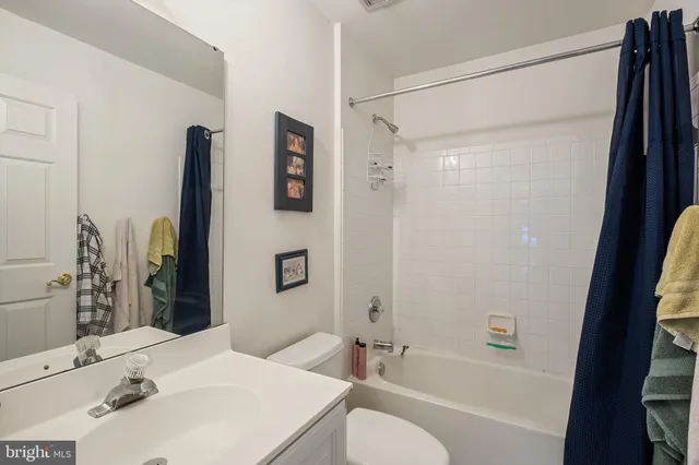 a bathroom with a granite countertop sink a mirror and a shower