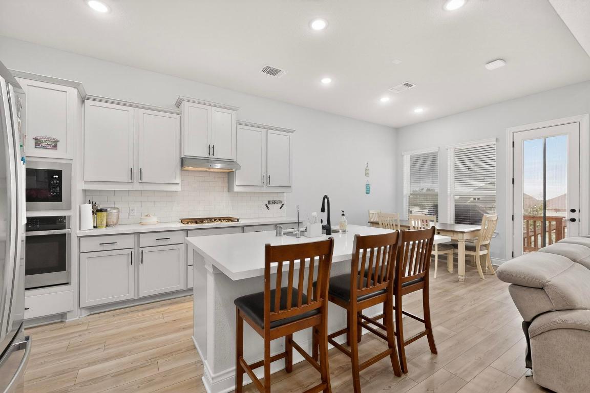 1304 Snowdrop Drive Georgetown, TX 78628 - Photo 10 of 27 a kitchen with stainless steel appliances granite countertop a table chairs sink and cabinets