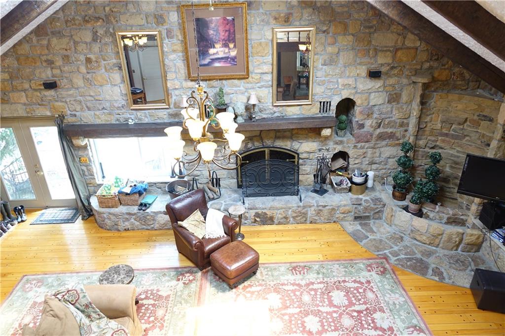 227 Meridian Road Butler, PA 16001 - Photo 11 of 25 First floor family room with stone fireplace, cathedral ceiling, hardwood flooring, and glass doors which lead to the inground pool.