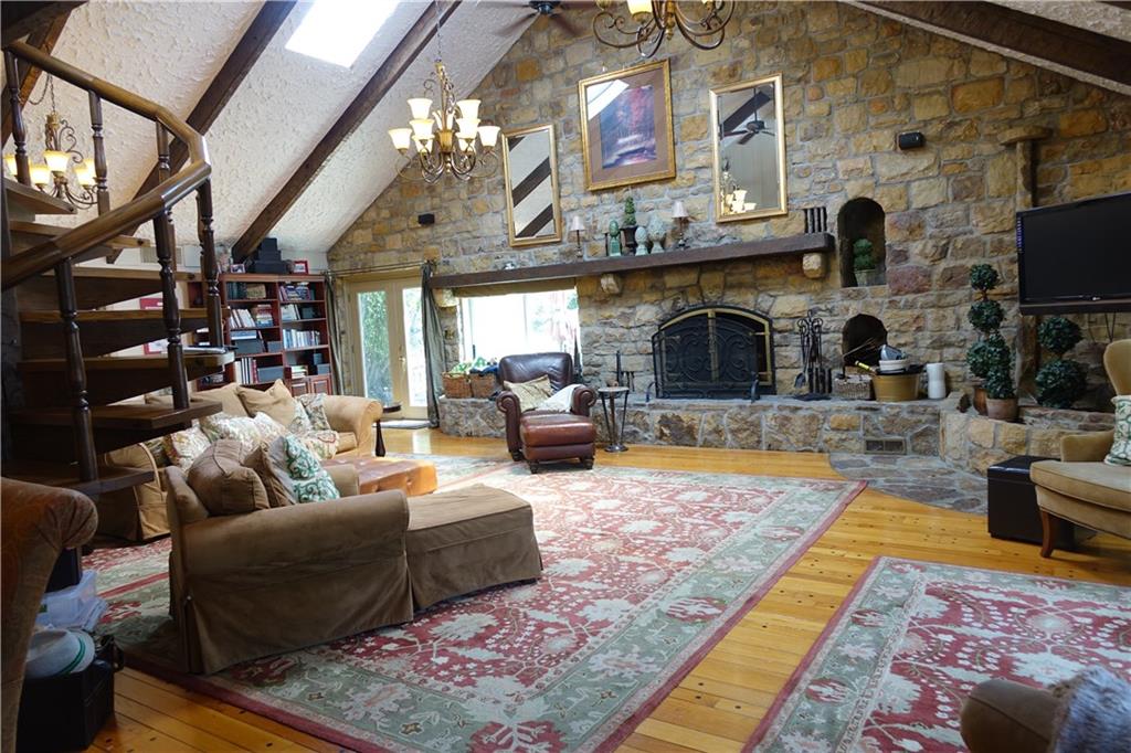 227 Meridian Road Butler, PA 16001 - Photo 10 of 25 First floor family room with stone fireplace, cathedral ceiling, hardwood flooring, and glass doors which lead to the inground pool.