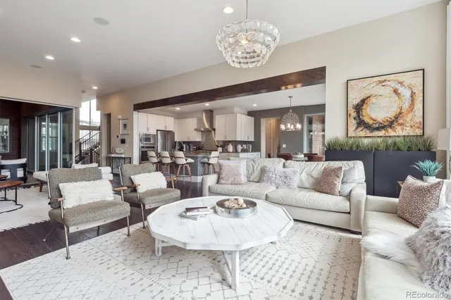 a living room with furniture chandelier and kitchen view