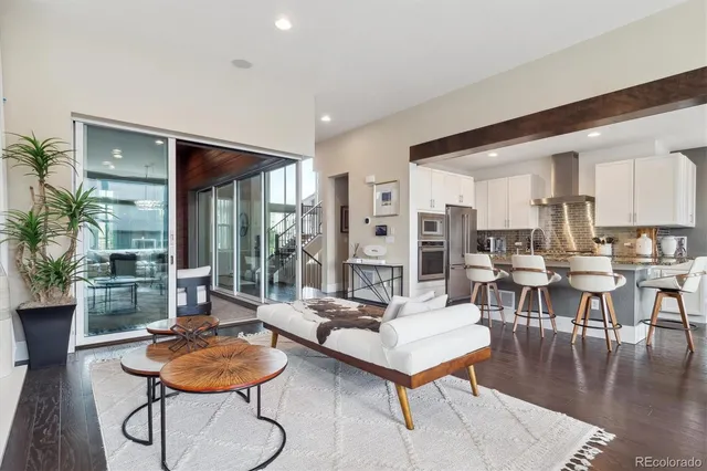 a living room with furniture kitchen view and a large window