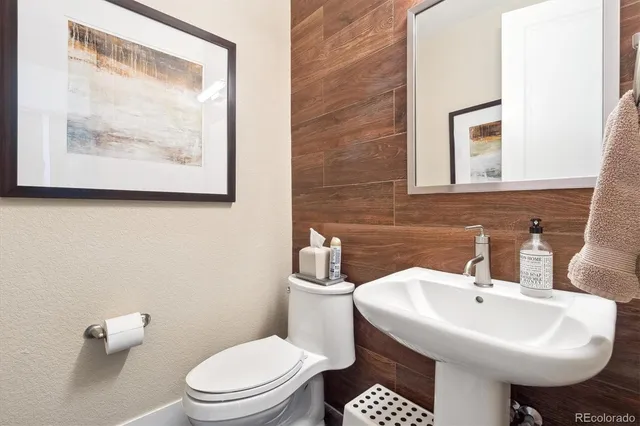 a bathroom with a toilet a sink and mirror