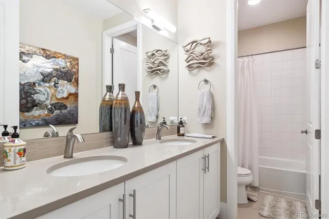 a bathroom with a double vanity sink toilet and shower