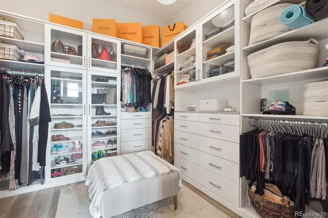 a view of walk in closet with clothes and shoes