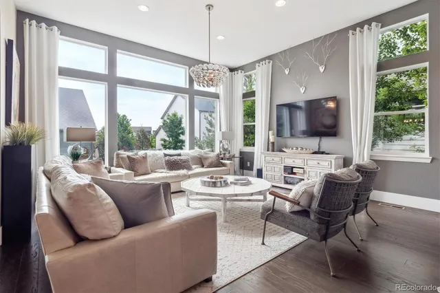 a living room with furniture a flat screen tv and a large window