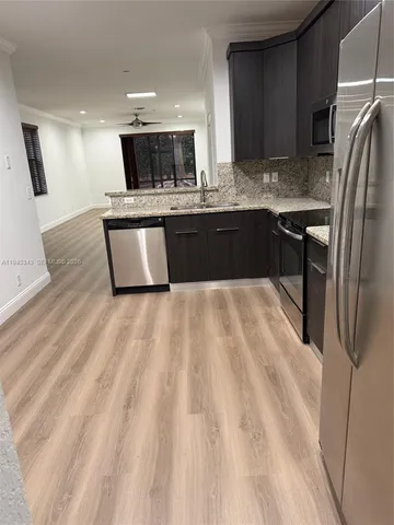 a large kitchen with stainless steel appliances kitchen island a large counter top and a sink