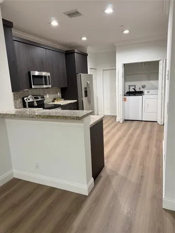 a kitchen with stainless steel appliances granite countertop a refrigerator a sink a stove a microwave and cabinets