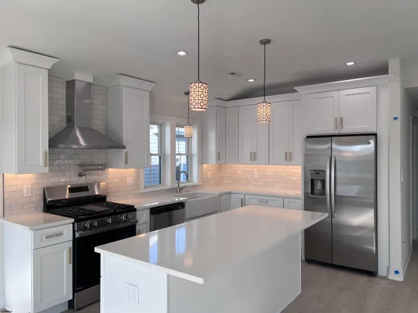a kitchen with stainless steel appliances granite countertop a sink a stove and a refrigerator