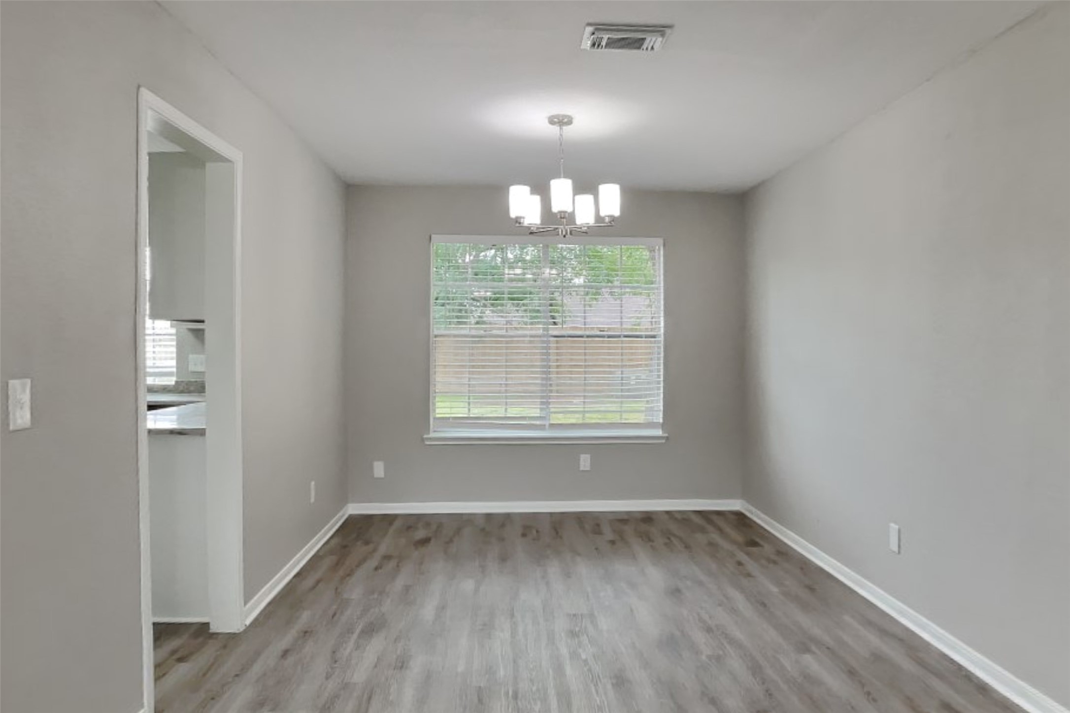 16303 Hickory Point Road Houston, TX 77095 - Photo 6 of 21 an empty room with wooden floor and windows