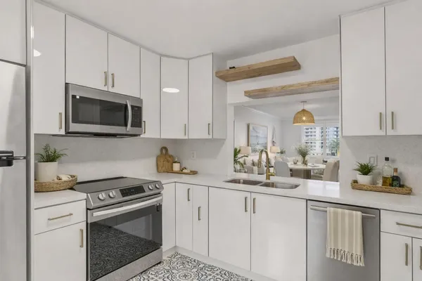 a kitchen with white cabinets and appliances