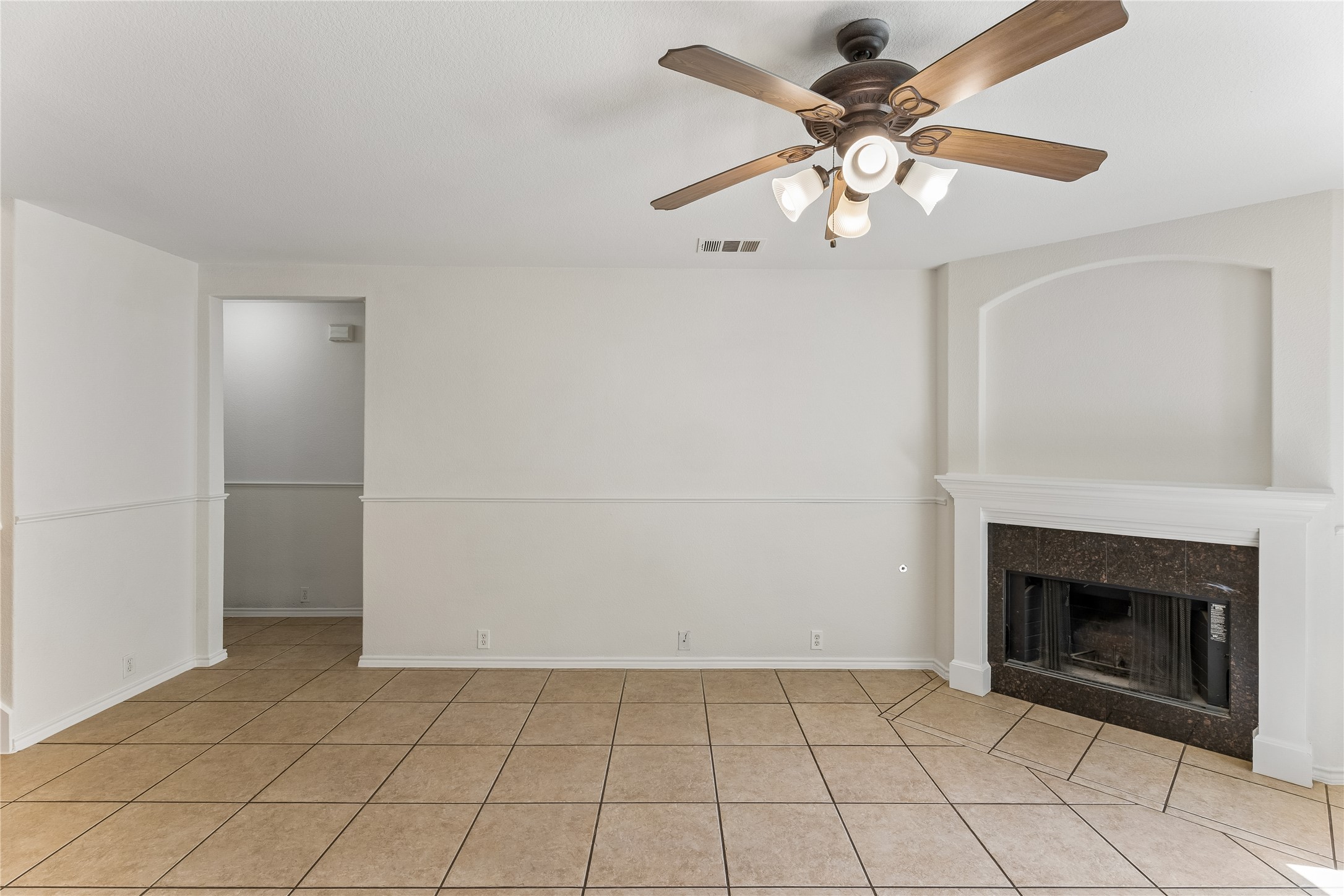 2372 Paradise Ridge Drive Round Rock, TX 78665 - Photo 14 of 40 A well-lit living area features neutral walls and an inviting tile floor, centered around a cozy fireplace.