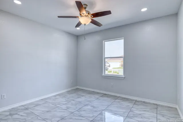 an empty room with a window and a fan
