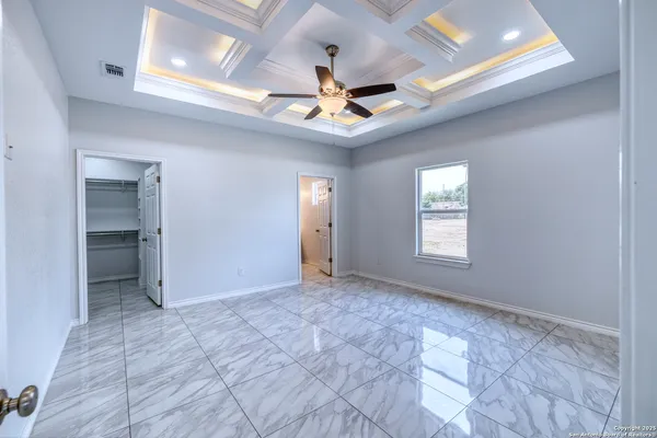 an empty room with windows and fan