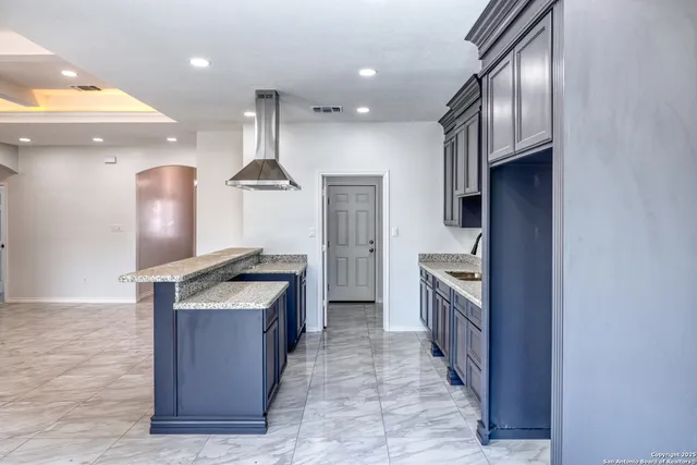 a kitchen with stainless steel appliances granite countertop a stove a sink and a refrigerator