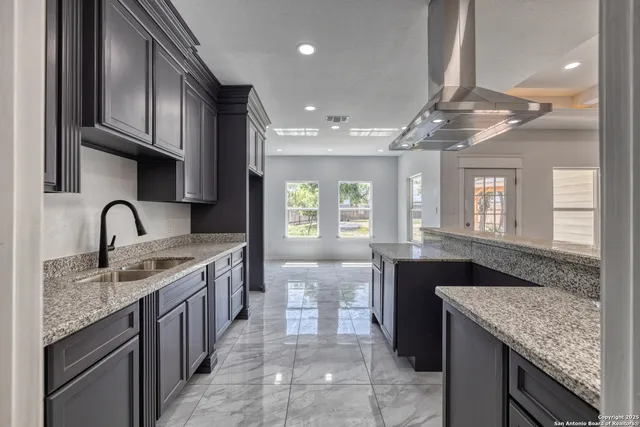 a kitchen with stainless steel appliances granite countertop a sink and stove