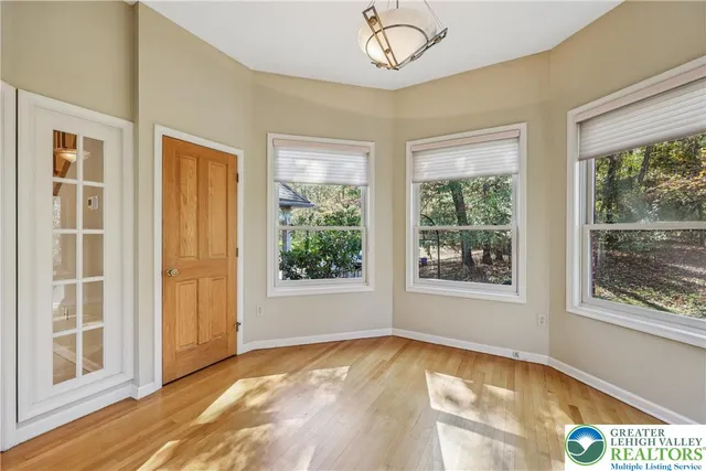 a spacious bedroom with a large bed a chandelier and a flat tv screen