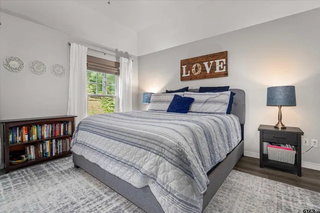 a bedroom with a bed and a lamp on dresser