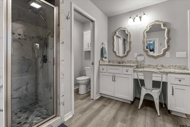 a spacious bathroom with a granite countertop sink mirror and a shower