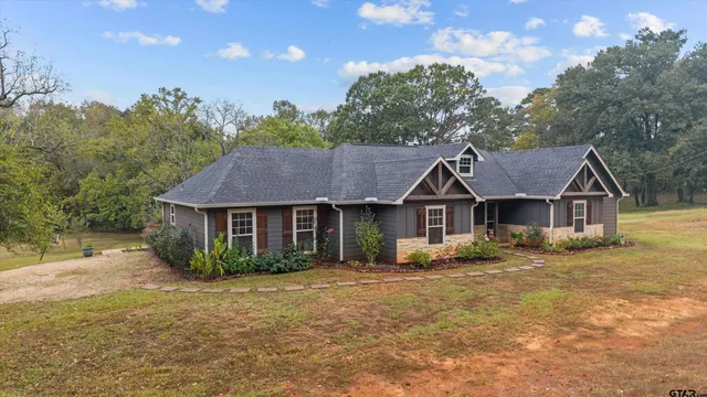 an aerial view of a house with yard and lake view