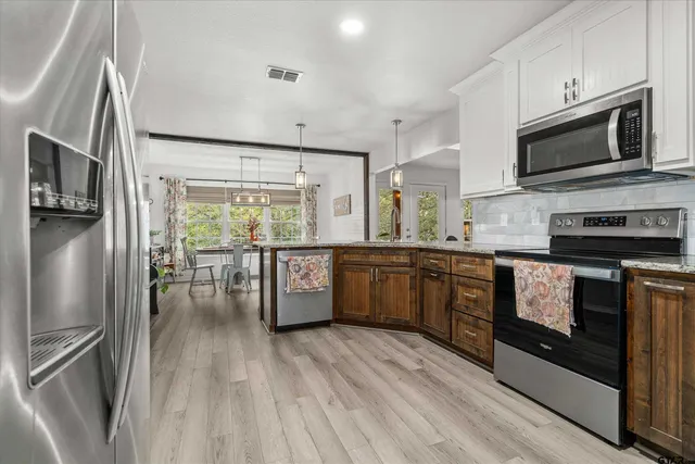 a kitchen with stainless steel appliances a stove a sink refrigerator and microwave