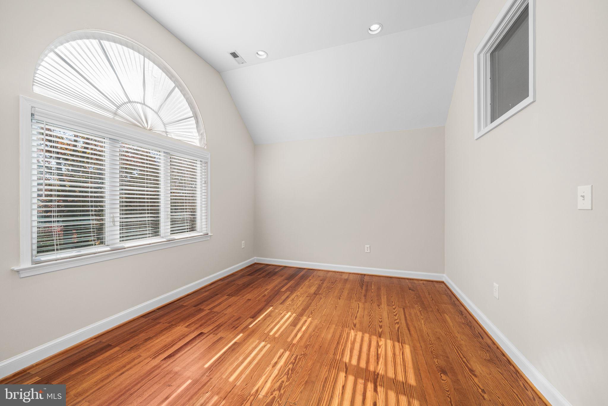 4613 8th Road South Arlington, VA 22204 - Photo 32 of 59 an empty room with wooden floor a exposed radiator and a window