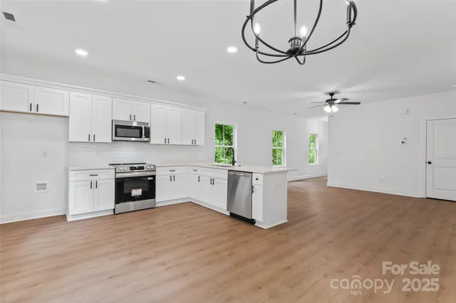 a kitchen with stainless steel appliances a stove a sink and a refrigerator
