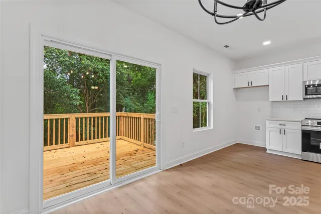 a view of a kitchen with a stove wooden floor and a window