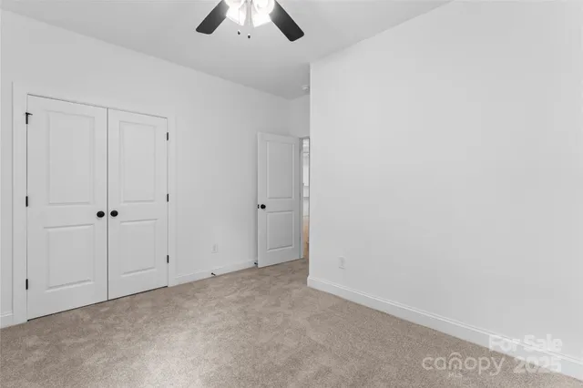 an empty room with chandelier fan