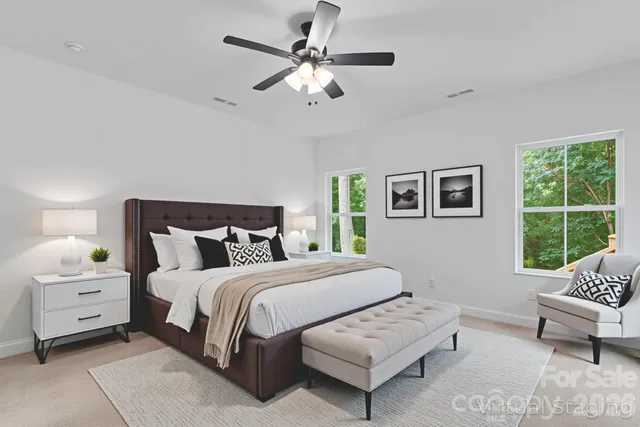 a bedroom with a bed a couch and window