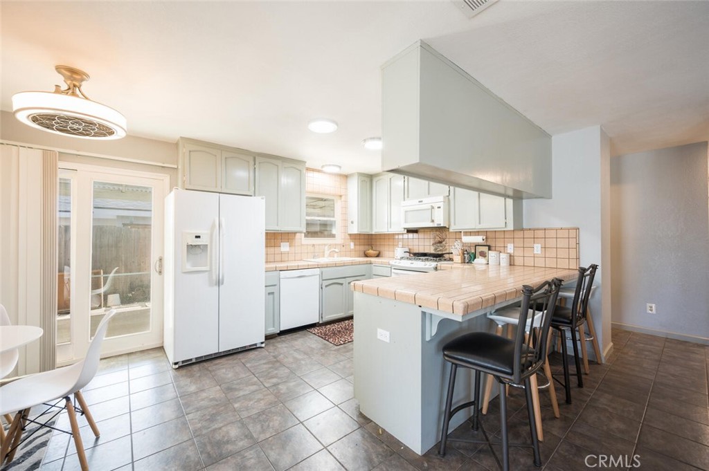 1503 17th Street Los Osos, CA 93402 - Photo 14 of 35 a kitchen with a dining table chairs and refrigerator