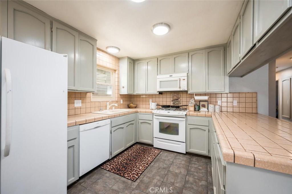 1503 17th Street Los Osos, CA 93402 - Photo 15 of 35 a kitchen with white cabinets appliances and a sink