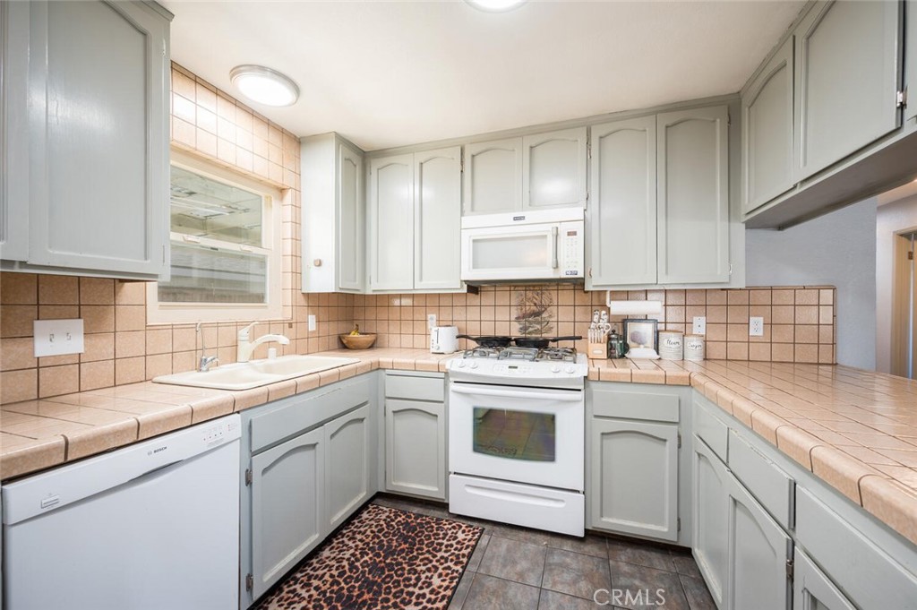 1503 17th Street Los Osos, CA 93402 - Photo 16 of 35 a kitchen with white cabinets appliances and a sink
