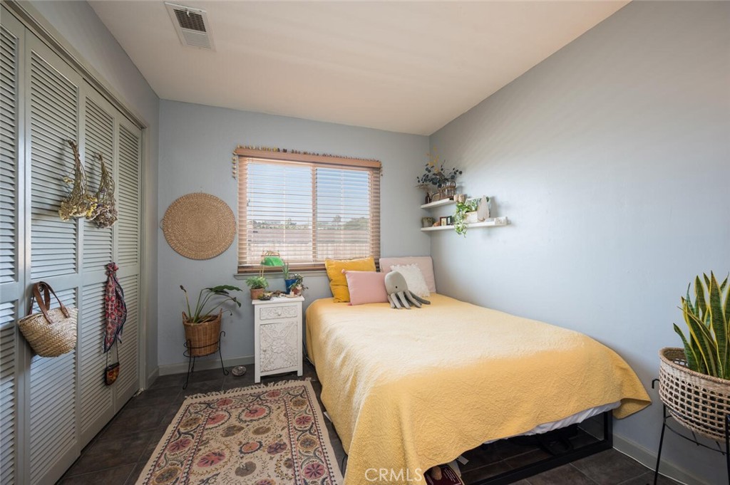 1503 17th Street Los Osos, CA 93402 - Photo 28 of 35 a bedroom with a bed and a chandelier