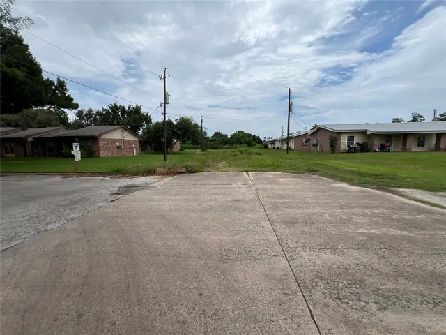 a view of a house with a big yard and palm trees