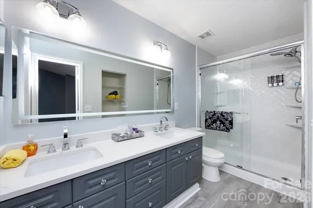 a bathroom with a granite countertop sink mirror vanity and toilet