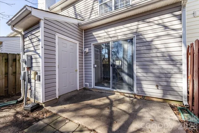 a view of backyard with large trees and wooden fence
