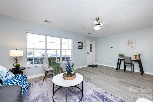 a living room with furniture and a wooden floor