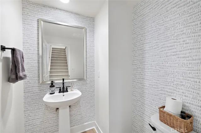 a living room with furniture kitchen view and a wooden floor